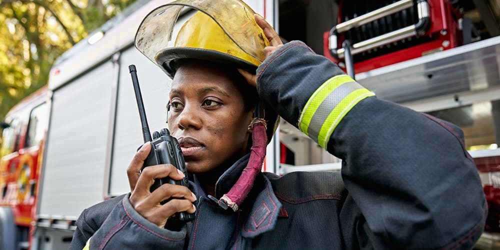 Firefighter using an Emergency Responder Radio Communication System (ERRCS). 