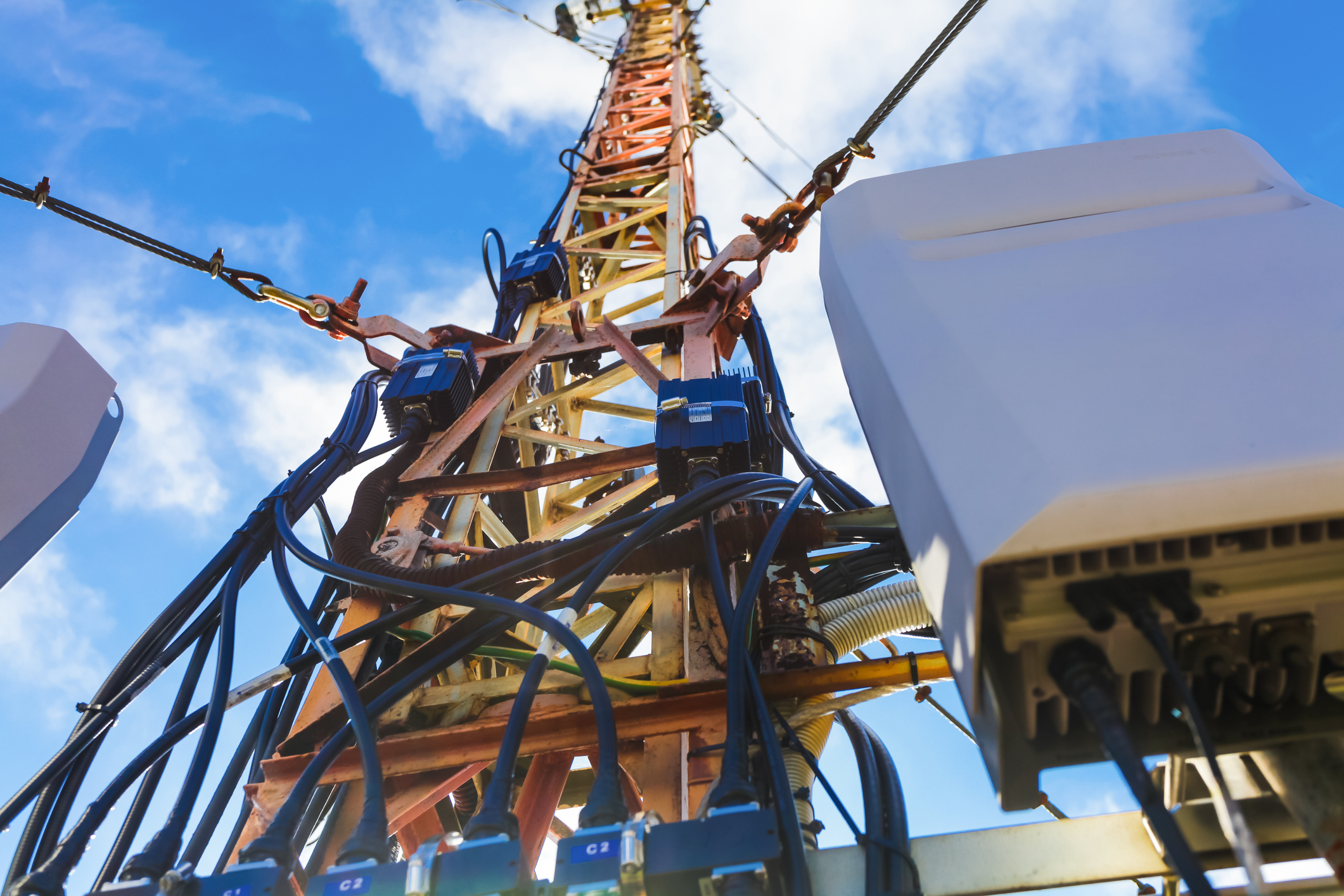 Cellular network tower against blue sky. 