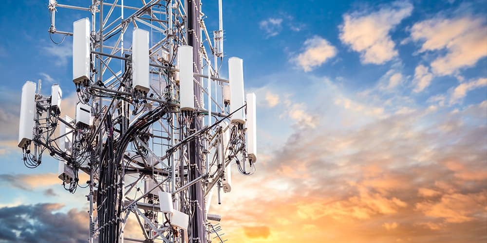 5G cell tower against a scenic sunset. 